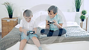 Two friends or brothers smiling and having fun playing a video game with controllers.