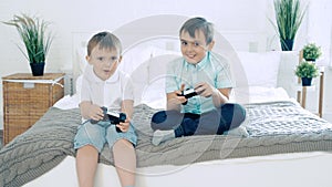 Two friends or brothers smiling and having fun playing a video game with controllers