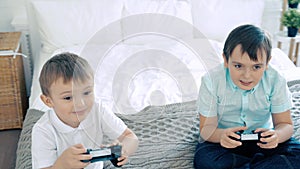 Two friends or brothers smiling and having fun playing a video game with controllers