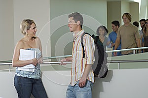 Two Friends Communicating At Corridor photo