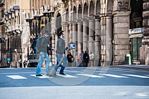 Two friends are crossing the street in busy area.