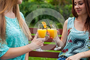 Two friends drink refreshing, cold orange juice.