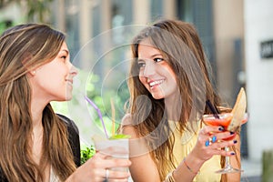 Two friends drinking a cocktail