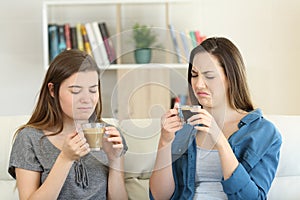 Two friends drinking coffee with bad flavour