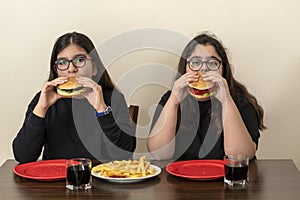 Two friends are eating fast food products