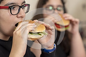 Two friends are eating fast food products