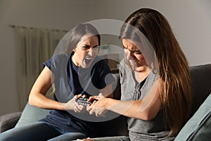 Two friends fighting for the tv remote control