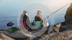 Two friends fishing to escape stressed city life, common interests, free time