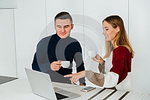 Two friends having conversation while looking at laptop screen