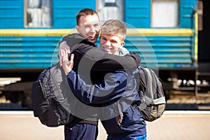 Two friends hugging after long separation at railway station