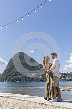 Two friends kissing on a sunny day on the beach in Lugano. They are in love