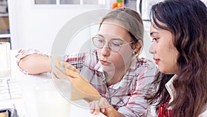 Two friends in kitchen, Woman at breakfast table Looking at Partner Messaging On Social Media