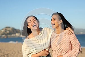 Two friends laughing hilariously on the beach photo
