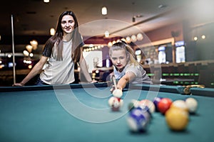 Two friends playing billiard in pub. Gambling concept