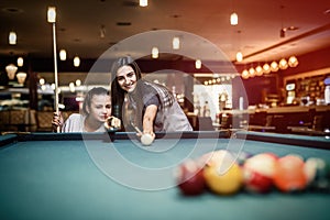 Two friends playing billiard in pub. Gambling concept