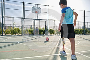 Two friends playing football, one has a leg prosthesis and is kicking a penalty.