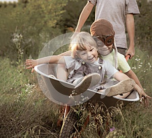 Two friends playing in the plane using a garden carts