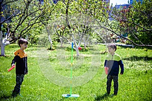 Two friends are playing tetherball swing ball game in summer camping. Two boy brother happy leisure healthy active time outdoors