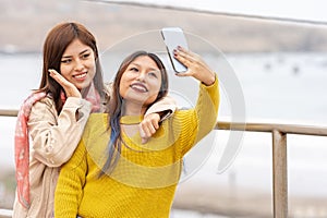 Two friends posing while taking a selfie outdoors