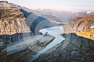 Two friends seats on Trolltunga in Norway