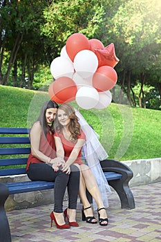 Two friends sitting on the bench with balls