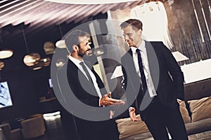 Two friends smiling while talking in the hotel hall