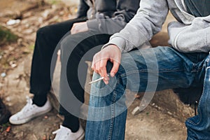 Two friends smoking joint in abandoned ghetto part of city