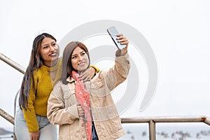 Two friends taking a selfie with a mobile in the street