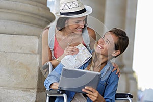 Two friends visiting foreign city one sitting in wheelchair