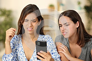 Two friends watching nasty content on phone