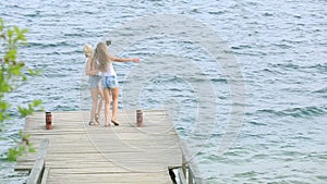 Two friends women taking selfie with mobile phone near the river. Two young girls enjoying near river and taking selfie