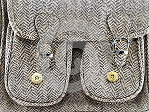 two front pockets with golden peg magnet and buckle strap on beige leather bag