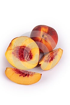 Two fruits of a peach nectarine subspecies with a smooth peel lie on the surface of a white backlit in the center