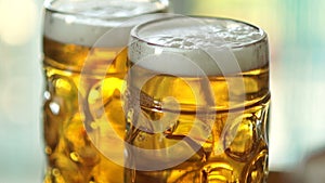 Two full glasses of cold beer. Close-up, visible foam and air bubbles in the glass. Glass of glasses fogged up