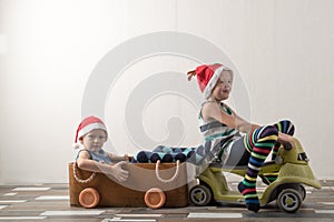 Two funny boys in a Santa Claus hat are playing with horses drawn on cardboard. The guys have fun at home. Christmas holiday conce