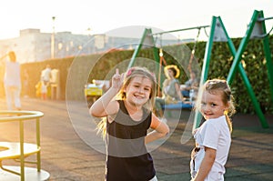 Two funny carefree little girls on the playground