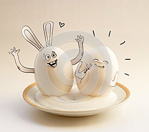 Two funny eggs on a saucer smiling. Happy Easter