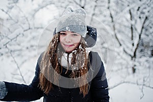 Two funny girls friends having fun at winter snowy day near snow covered trees