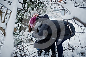 Two funny girls friends having fun at winter snowy day near snow covered trees