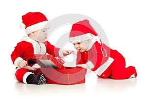 Two funny kids in Santa clothes with gift box
