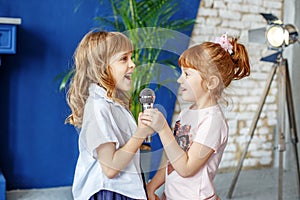 Two funny kids sing a song in karaoke. The concept is childhood,