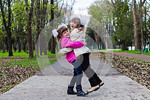 Two funny siblings sister hugging with each other while walk in park