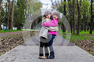 Two funny siblings sister hugging with each other while walk in park