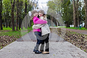 Two funny siblings sister hugging with each other while walk in park