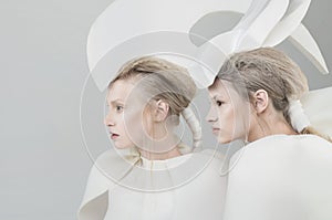 Two futuristic blonde women in white outfit over w