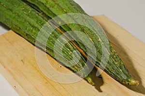 Two gambas or oyong or luffa gourd fruits on a wooden cutting board