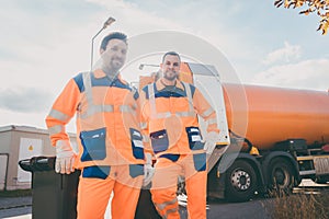 Two garbage removal service workers having short break