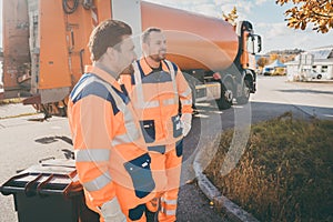 Two garbage removal service workers having short break