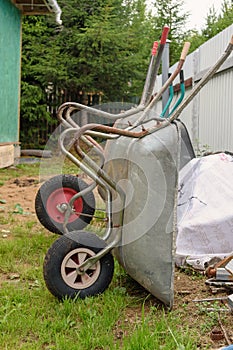 Two garden wheelbarrows leaning against the fence. Gardening