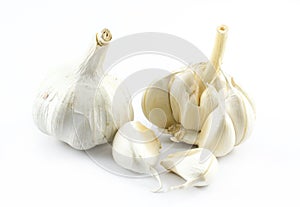 Two garlic pieces and cloves on a white background